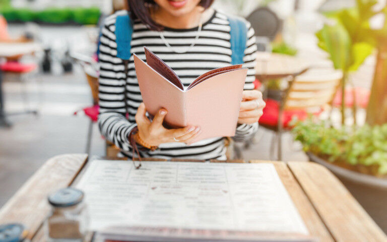 young woman reading a menu at a restaurant