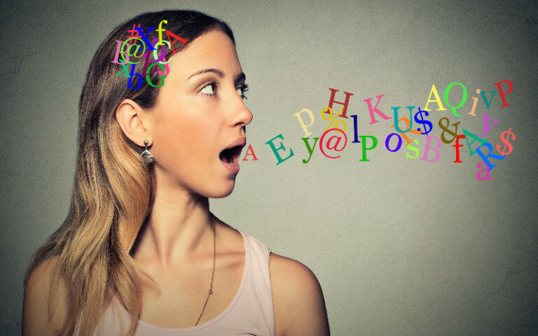 Side view portrait woman talking with alphabet letters in her head and coming ou