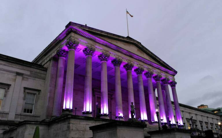 UCL’s Portico building at dusk. The columns of the building are illuminate