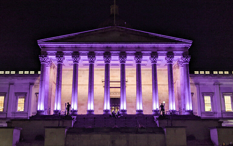 The UCL Portico lit purple at night